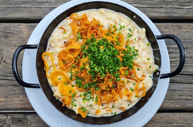 Käsespätzle in der Pfanne mit geröteten Zwiebeln und Schnittlauch