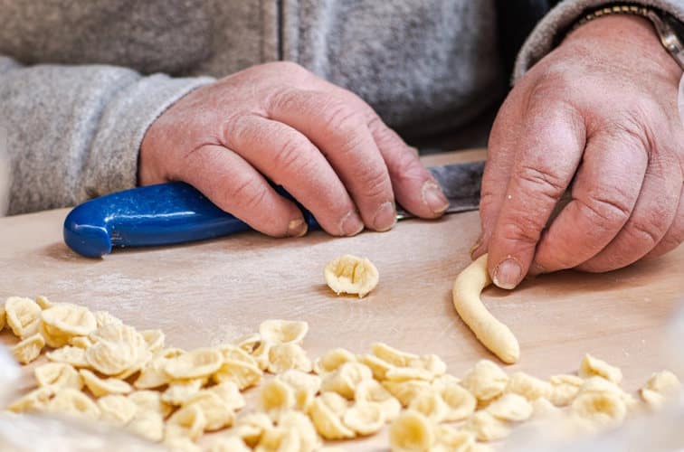 Eine Nudelfrau bei ihrer Arbeit in der Strada delle Orecchiette