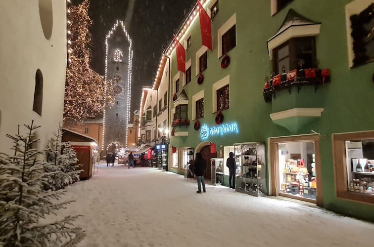 Die Altstadt von Sterzing im Winter mit dem Wahrzeichen Zwölferturm und dem Kaufhaus Mair Mair